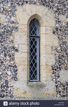 an old stone building with a window and iron bars