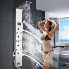 a woman standing in front of a shower head with water coming out of the faucet