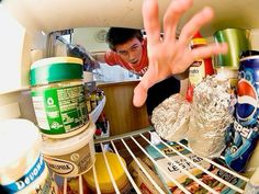 a person reaching for food in an open refrigerator