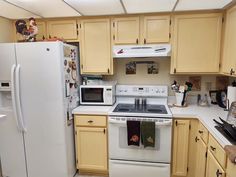 a white refrigerator freezer sitting inside of a kitchen next to a stove top oven