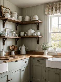 a kitchen filled with lots of white dishes and wooden counter tops next to a window