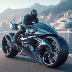 a man riding on the back of a motorcycle down a street next to a body of water