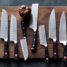 several knives are lined up on a cutting board