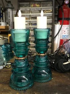 two teal glass candlesticks sitting on top of a wooden table next to other items