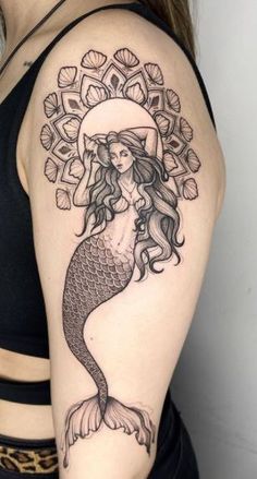 a woman's arm with a tattoo on it and an image of a mermaid