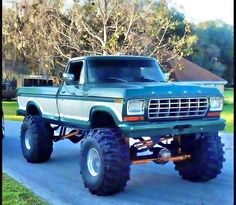 a large green truck parked on the side of a road