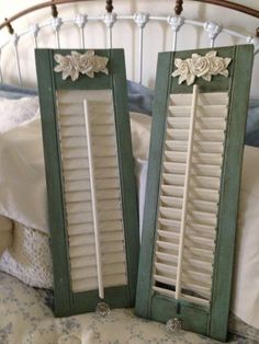 two green shutters sitting on top of a bed