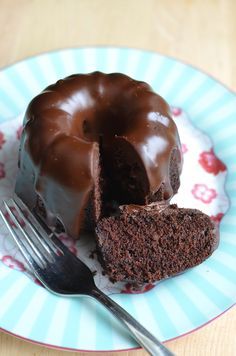 a chocolate bundt cake on a blue and white plate with a bite taken out