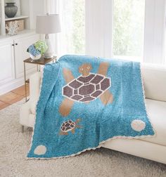 a turtle blanket on a couch in a living room