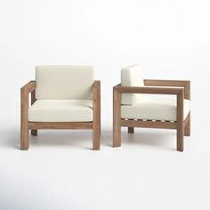 two wooden chairs sitting next to each other on a white surface with one chair facing the other