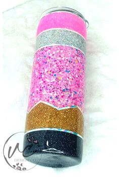 a pink and gold canister with glitter on the side, sitting on a white surface