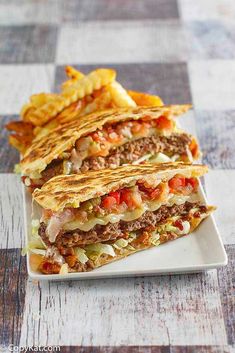 three quesadillas stacked on top of each other with chips in front of them