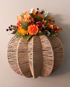 a wicker pumpkin shaped wall hanging with flowers