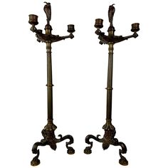 a pair of antique brass candlesticks with birds on the top and one candle holder in the middle