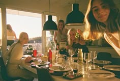 a group of people sitting around a table with wine glasses on it and plates in front of them