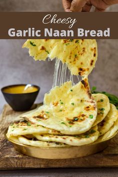 garlic naan bread being lifted from a pan