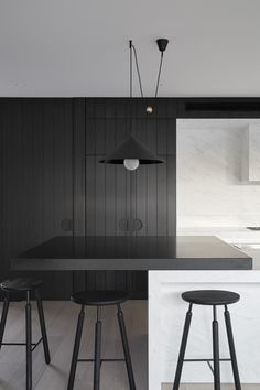 a black and white kitchen with bar stools