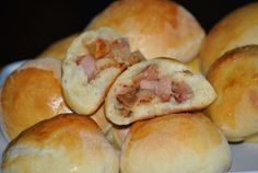 rolls filled with meat sitting on top of a white plate