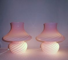 two pink vases sitting next to each other on a table