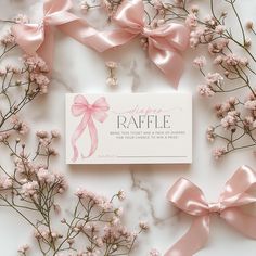 some pink bows and flowers on a white table