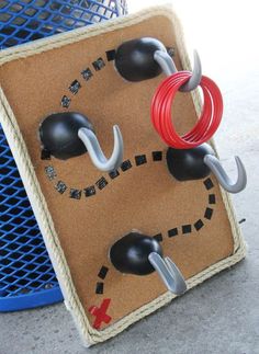 two hooks are attached to the side of a piece of cardboard with red and black wires