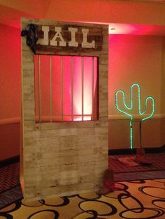 an entrance to a jail cell with neon lights on the walls and a cactus in the doorway