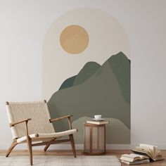 a chair and table in front of a wall with a mountain scene painted on it