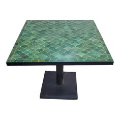 a table with green tiles on it and a black metal stand in front of it