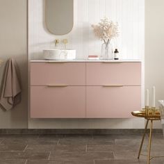 a bathroom with pink cabinets and white walls