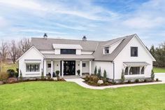 a large white house sitting on top of a lush green field