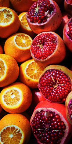 oranges, pomegranates and other fruits are arranged in a pile