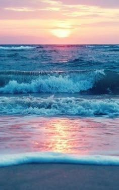 the sun is setting over the ocean waves