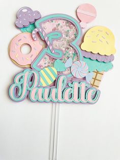 a birthday cake topper with donuts, ice cream and sprinkles