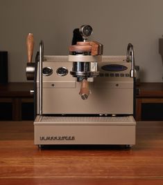 an espresso machine sitting on top of a wooden table