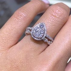 a close up of a person's hand with a diamond ring on their finger