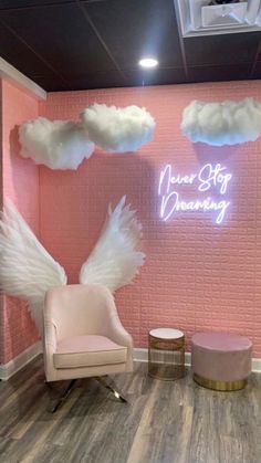 a pink room with angel wings on the wall