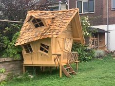 a small wooden house sitting on top of a lush green field