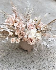 a vase filled with flowers on top of a cement ground