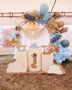 a table with balloons and decorations in the shape of clouds on top of two containers