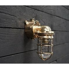 a close up of a light on the side of a building with wood planks