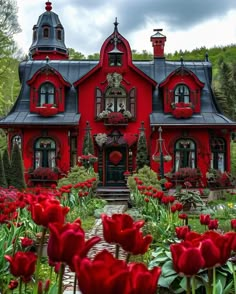 a red house with lots of flowers around it