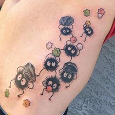 a woman's stomach with tattoos on it and some small cartoon characters in the middle