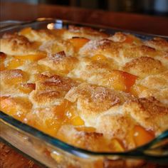 a casserole dish filled with peaches on top of a wooden table