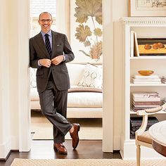 a man in a suit and tie is standing in the doorway to his living room