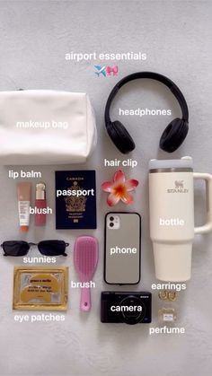 the contents of a travel bag laid out on top of a white surface with earphones, hairbrushes, and other items