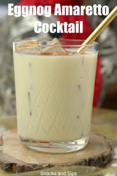 an eggnog amaretto cocktail in a glass with a gold straw