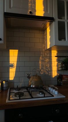 a stove top oven sitting inside of a kitchen next to white cabinets and counter tops