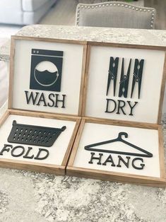 three signs that say wash, dry and fold hang on a counter top next to a chair