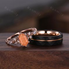 two wedding rings with an orange stone in the middle