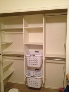 an empty closet with two baskets on the bottom shelf and one basket in the middle